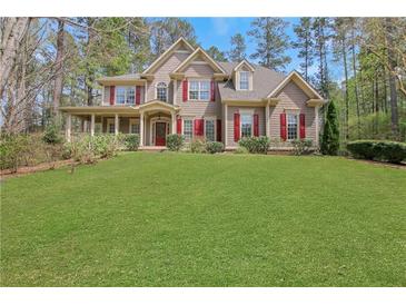 Charming two-story home with a well-manicured lawn and a welcoming front porch with decorative red shutters at 2320 Starr Lake Nw Dr, Acworth, GA 30101