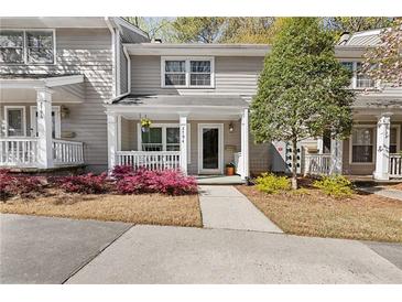 Charming townhome with a well-manicured front yard, covered porch, and neutral siding at 2794 Farmstead Se Rd, Smyrna, GA 30080