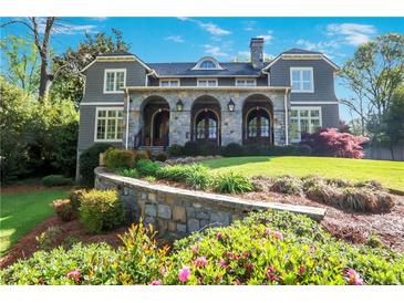 Charming gray home with stone arches and lush landscaping in a desirable neighborhood at 1691 Doncaster Ne Dr, Atlanta, GA 30309