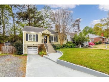 Charming home featuring a well-manicured lawn, inviting front porch, and convenient garage at 51 Willow Wood Se Cir, Atlanta, GA 30317