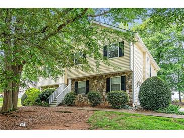 Charming two-story home with stone accents and lush greenery in a well-maintained front yard at 1019 James Madison Ct, Mcdonough, GA 30253