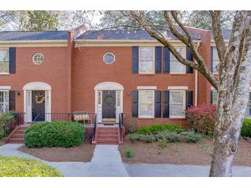 Beautiful brick townhome with black shutters, manicured landscaping, and inviting entrance at 102 Defoors Mill Dr, Atlanta, GA 30318