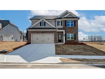 Charming two-story home with brick accents, attached two-car garage, and well-manicured lawn at 412 Westmarch Cir, Loganville, GA 30052