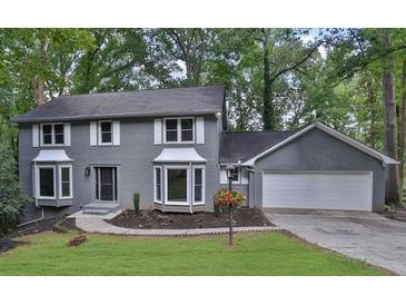 Charming two-story home with gray brick exterior and well-manicured front lawn at 9415 Martin Rd, Roswell, GA 30076