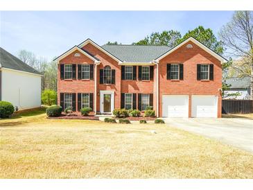 Charming two-story brick home featuring an attached two-car garage and meticulously maintained landscaping at 3903 Cain Mill Dr, Lithonia, GA 30038
