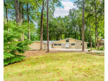 Inviting single-story home featuring stone accents, ample windows, and a lush front lawn with mature trees at 247 Old Timber Rd, Lawrenceville, GA 30046