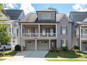 Charming two-story home featuring a welcoming front porch, attached garage and manicured lawn at 319 Riverton Way, Woodstock, GA 30188