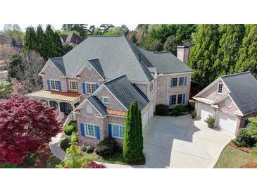 Stately brick home boasts a three-car garage, mature landscaping, and architectural details at 2510 Bent Creek Way, Cumming, GA 30041