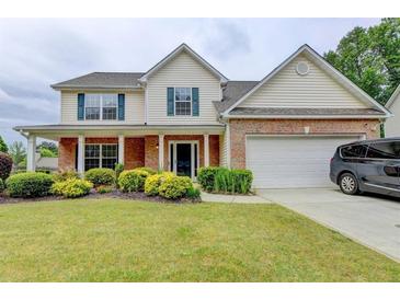 Charming two-story home featuring a manicured lawn, brick accents, and a two-car garage at 3285 Watson Gate Rd, Loganville, GA 30052