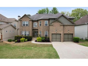 Charming brick home featuring manicured landscaping, a two-car garage, and a welcoming front entrance at 4015 Brookhollow Dr, Douglasville, GA 30135