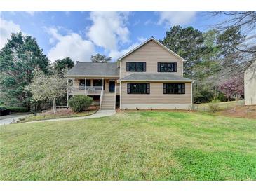 Charming two-story home with a well-manicured lawn and mature trees at 417 Wood Branch St, Woodstock, GA 30188
