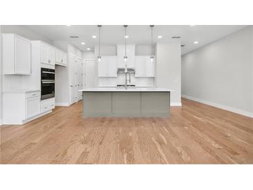 Bright kitchen with stainless steel appliances, white cabinets and a large gray kitchen island at 2540 Silver Star Ne Dr, Marietta, GA 30066