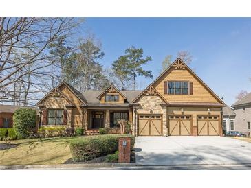 Inviting front exterior features a three-car garage, manicured lawn, and attractive mix of stone and siding accents at 2674 Hosanna Dr, Powder Springs, GA 30127
