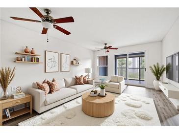 Bright living room features hardwood floors, ceiling fan, and sliding glass doors to outdoor balcony at 66 Fair Haven Se Way, Smyrna, GA 30080