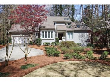 Charming home featuring a well-manicured lawn with mature landscaping and a two-car garage at 80 Seville Chase, Atlanta, GA 30328