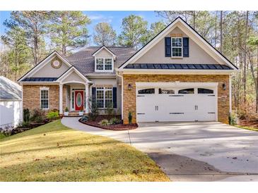 Charming home featuring stone accents, a red front door and a two-car garage at 1409 Northgate Dr, Villa Rica, GA 30180