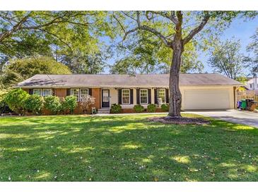 Charming single-story home with a well-manicured lawn and mature trees providing ample shade at 3113 Octavia Pl, Atlanta, GA 30340