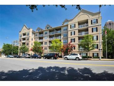 Exterior view of a modern condo building with balconies, manicured landscaping, and street parking at 1075 Peachtree Ne Walk # A519, Atlanta, GA 30309