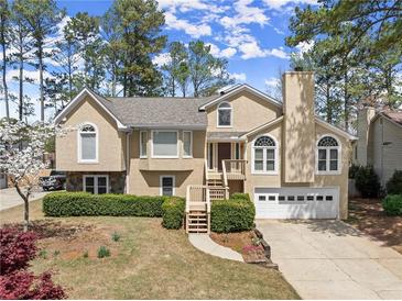 Charming two-story home with manicured front lawn and two-car garage and elegant entrance, perfect for Gathering living at 465 Hunt River Way, Suwanee, GA 30024