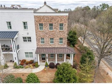 Charming brick townhouse featuring a welcoming front porch and manicured landscaping at 2026 Forte Ln, Alpharetta, GA 30009