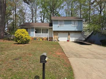 Charming two-story home with stone accents, attached two-car garage, front porch, and blossoming shrub at 3657 Willow Wood Way, Lawrenceville, GA 30044