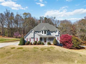 Charming two-story home with manicured lawn, colorful trees, and inviting front porch at 1130 Martins Chapel Rd, Lawrenceville, GA 30045