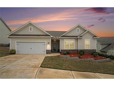 Charming single-story home featuring a two-car garage, landscaped yard, and stone accents at 1640 Andalusian Way, Conyers, GA 30012