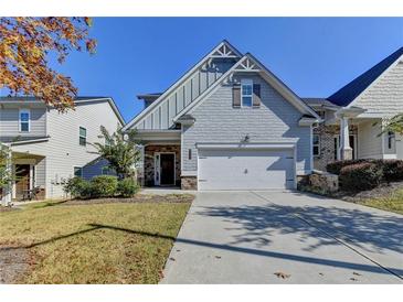 Charming home with a two-car garage, gray siding, stone accents, and a well-manicured lawn at 4569 Grenadine Cir, Acworth, GA 30101