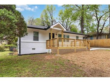Charming white home with a welcoming wooden front porch and freshly painted white brick foundation at 2297 Sheryl Dr, Decatur, GA 30032