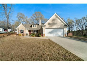 Charming home featuring a well-manicured lawn, two-car garage, and traditional architectural details at 338 Rc Thompson Rd, Dallas, GA 30157