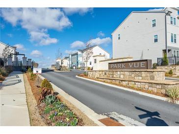Community street view showcases sidewalks, landscaping, and varied home styles on a sunny day at 1520 Parks Edge Nw Ln, Atlanta, GA 30318
