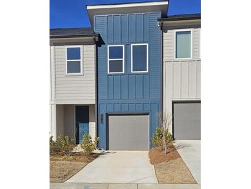 Charming townhome exterior with a one-car garage and a modern blue facade at 1512 Parks Edge Nw Ln, Atlanta, GA 30318