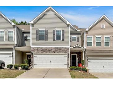 Charming townhome with a two-car garage, stone accents, and well-maintained landscaping at 485 Crescent Woode Dr, Dallas, GA 30157