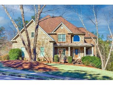 Charming two-story home featuring a brick and stone facade, covered porch and beautifully landscaped yard at 1526 Rocky River Dr, Lawrenceville, GA 30045
