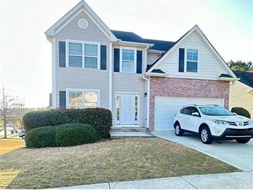Charming two-story home with a well-manicured lawn and a white SUV parked in the driveway at 771 Franklin Mill Trce, Loganville, GA 30052