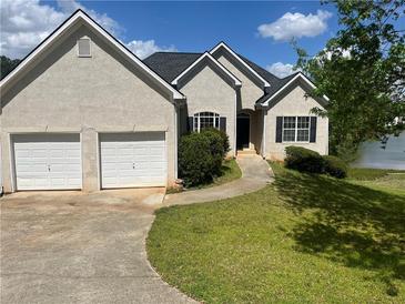 Charming stucco home featuring an attached two-car garage and lakeside views at 203 Sea Marsh Ct, Fayetteville, GA 30215