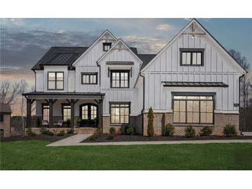 Stunning two-story home boasts white siding, black trim windows and covered porch with rocking chairs at 13415 Bishops Ct, Roswell, GA 30075