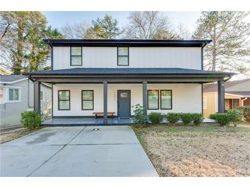 Charming two-story home featuring a welcoming front porch, black framed windows, and a well-maintained lawn at 1506 Avon Sw Ave, Atlanta, GA 30311