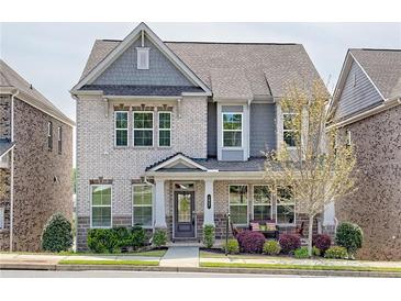 Charming two-story brick home with a covered front porch and manicured landscaping at 1867 Sterling Chase, Buford, GA 30518