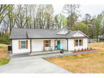Charming one story home featuring a freshly painted white exterior with a welcoming cyan front door at 5747 S Gordon Rd, Austell, GA 30168