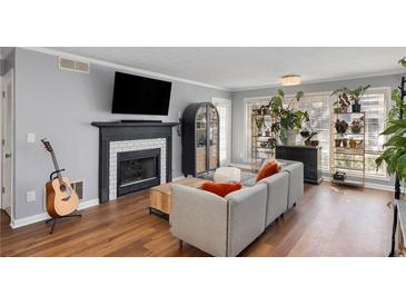 Inviting living room features a fireplace, large windows, and hardwood floors for a warm and bright space at 303 Gettysburg Pl, Atlanta, GA 30350