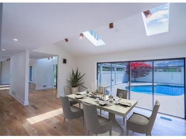 Bright dining room boasts skylights and sliding glass doors to the outdoor pool area at 541 Earlvine Nw Way, Kennesaw, GA 30152
