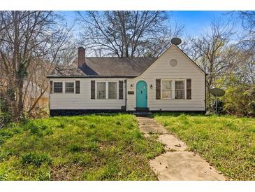 Charming home with a traditional design, a small yard, a teal-colored door, and shuttered windows at 16 Grove Park Nw Pl, Atlanta, GA 30318