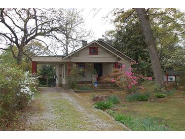 Charming home exterior featuring a covered carport, landscaping, and a welcoming front yard at 1130 Ridge Ave, Stone Mountain, GA 30083