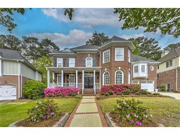 Beautiful two-story brick home with a welcoming front porch and meticulously landscaped yard at 1956 Grace Arbor Ne Ct, Atlanta, GA 30329