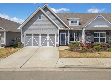 Charming home with a two-car garage, stone accents, and a well-maintained front yard at 510 Riverview Ln, Canton, GA 30114