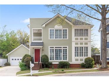 Charming two-story home with a red front door, green siding, and a well-manicured lawn and landscaped front yard at 218 Ridley Ln, Decatur, GA 30030