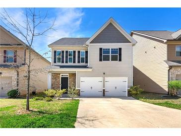 Charming two-story home featuring a two-car garage and well-maintained front yard at 11973 Lovejoy Crossing Way, Hampton, GA 30228