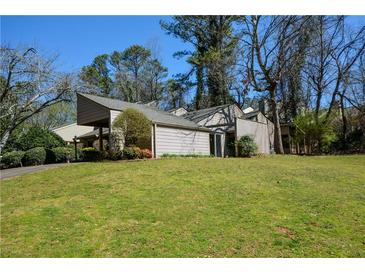 Charming single-story home featuring a carport, mature trees, and a well-manicured lawn at 154 Weatherly Way, Alpharetta, GA 30009
