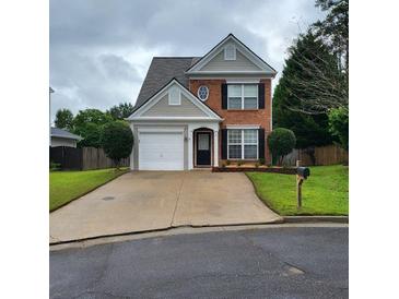 Charming two-story home with brick and siding exterior and well-maintained front yard with driveway and landscaping at 1503 Korona Ct, Woodstock, GA 30188